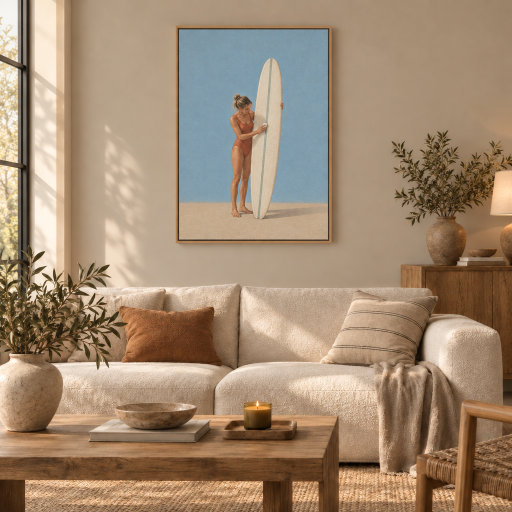 Vor der ersten Welle – Surferin Wandbild als Leinwand im Naturholz-Schattenfugenrahmen über einem cremefarbenen Sofa im Wohnzimmer.